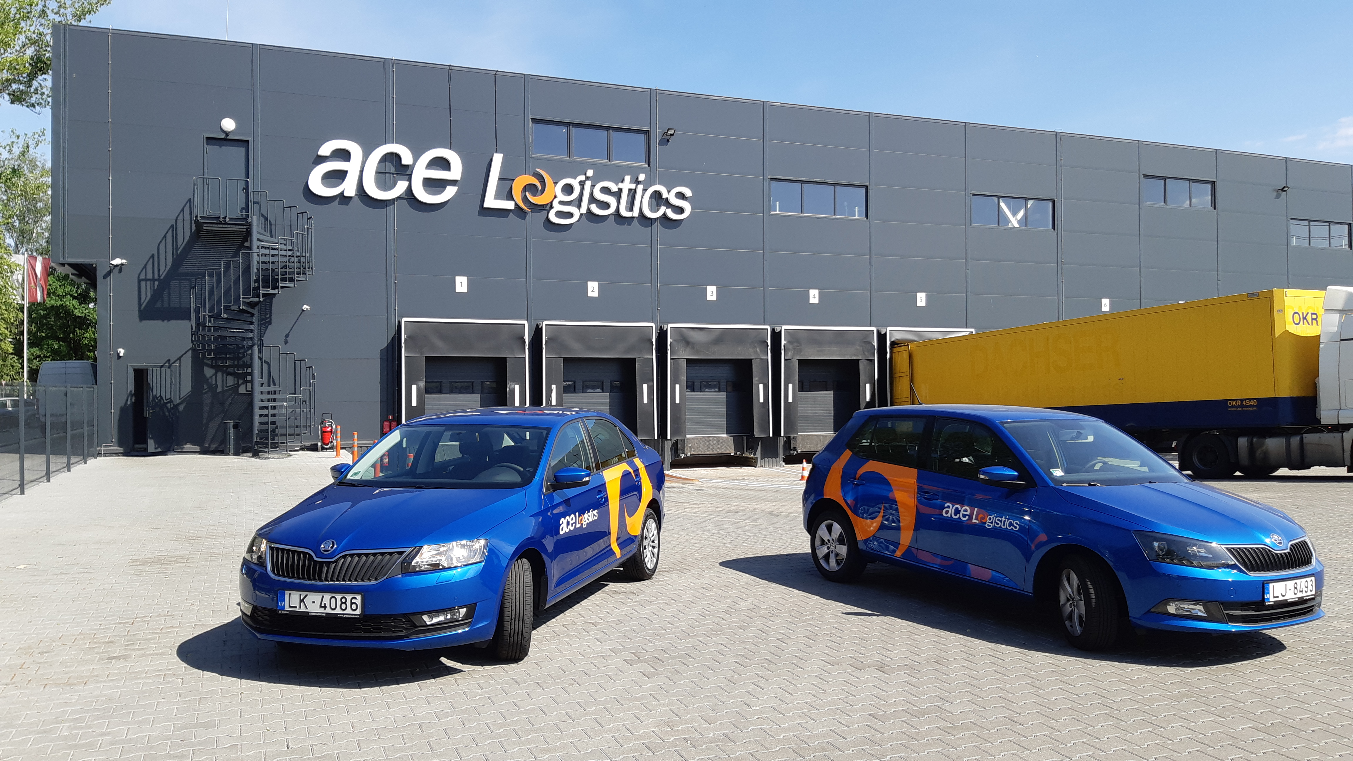 ace Logistics automašīnas, fonā ofisa ēka